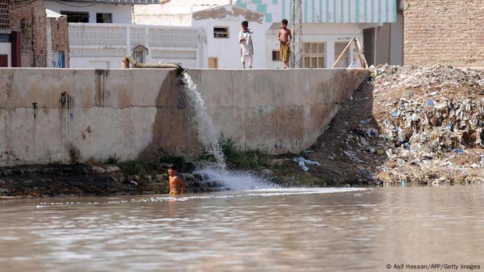 Children bathing near in Indus as sewage flows in