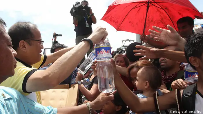epa03943724 A picture made available by the Malacanang Photo Bureau shows President Benigno S. Aquino III (2-L) gives out water to families displaced by Typhoon Haiyan during his visit to Tacloban City in the province of Leyte in Philippines, 10 November 2013. Typhoon Haiyan tore through the eastern and central Philippines beginning 08 November, flattening homes, toppling power lines and knocking out communications. Fierce winds ripped roofs off buildings as raging floodwaters swept debris and left vehicles piled on top of each other on the battered streets. The official death toll was 138, according to the national disaster relief agency. But official said, the toll could reach 10,000 in one city alone. EPA/RYAN LIM/ MALACANANG PHOTO BUREAU HANDOUT EDITORIAL USE ONLY/NO SALES
