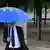 Ein Mann mit einem EU-Schirm - Foto: Wolfgang Kumm (dpa)
