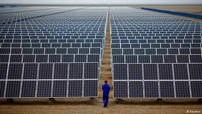 A worker inspects solar panels at a solar Dunhuang, 950km (590 miles) northwest of Lanzhou, Gansu Province in this September 16, 2013 file photo. China's loss-making solar panel makers believe they may have found a way out of their nightmare - by becoming one-stop renewable energy shops with their own solar farms. Picture taken September 16, 2013. REUTERS/Carlos Barria/Files (CHINA - Tags: ENERGY BUSINESS ENVIRONMENT)