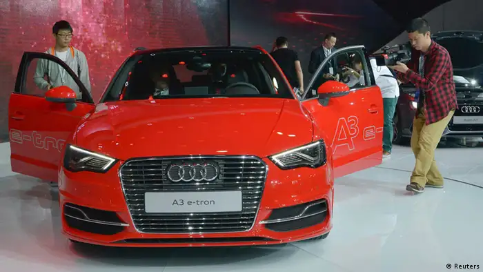 Visitors film an Audi A3 e-tron car at the Guangzhou International Automobile Exhibition in Guangzhou, Guangdong province, November 21, 2013. Luxury car dealers are resorting to offering customers massages, mini-golf and other gimmicks, hoping this will give them an edge in a ferociously competitive Chinese market where brand loyalty is less common than in the West. Audi will open its Innovation Exhibition at the Guangzhou auto show on Thursday, showcasing its technologies and concept cars such as the Crosslane Coupe, as well as the new generation Audi 3, including the plug-in hybrid A3 Sportback e-tron. REUTERS/Stringer (CHINA - Tags: TRANSPORT BUSINESS)