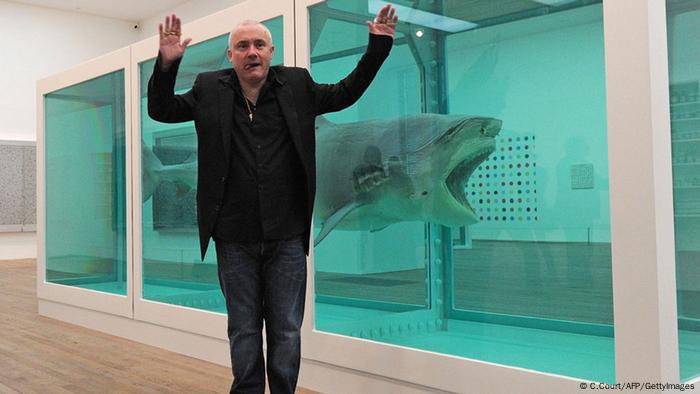 Damien Hirst in front of his shark in formaldehyde