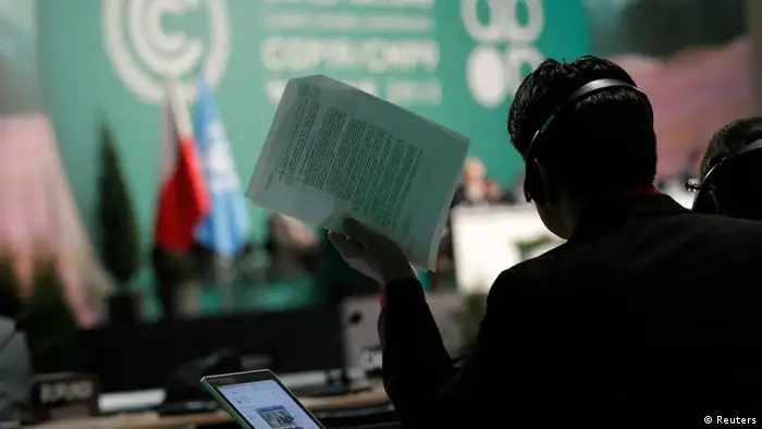 A man holds documents as he listens to statements of delegates during the 19th conference of the United Nations Framework Convention on Climate Change (COP19) in Warsaw November 23, 2013. REUTERS/Kacper Pempel (POLAND - Tags: ENVIRONMENT BUSINESS POLITICS)