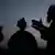The silhouettes of an interpreter, an Afghan local and an ISAF soldier
