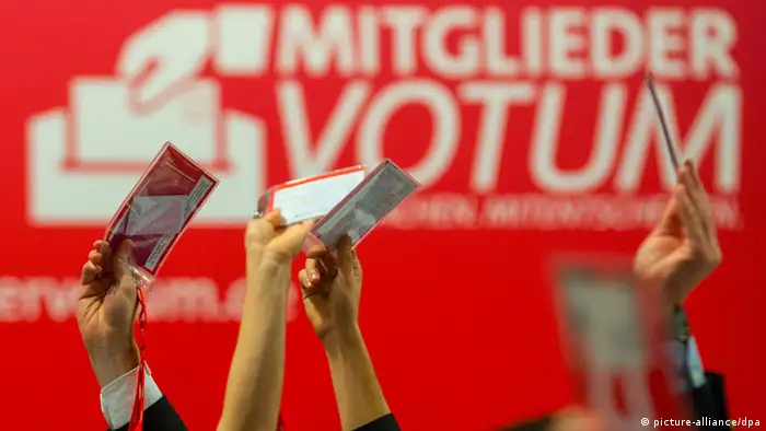 Delegierte stimmen am 15.11.2013 vor dem Logo des Mitglieder-Votums auf dem Parteitag der SPD in Leipzig über einen Antrag ab. Der SPD-Bundesparteitag dauert noch bis zum 16. November. Foto: Hannibal/dpa