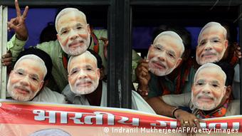Indian supporters of the Bharatiya Janata Party (BJP) wear masks of Gujarat state Chief Minister and the BJP's prime ministerial candidate, Narendra Modi, as they travel in a bus towards the airport to receive him in Mumbai on September 30, 2013 (Photo: INDRANIL MUKHERJEE/AFP/Getty Images)