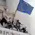 Молодые люди устанавливают флаг ЕС на здании парламента Молдавии