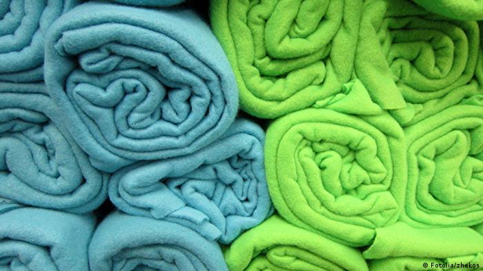 Blue and green fleece blankets rolled up and stacked. (© B747) 