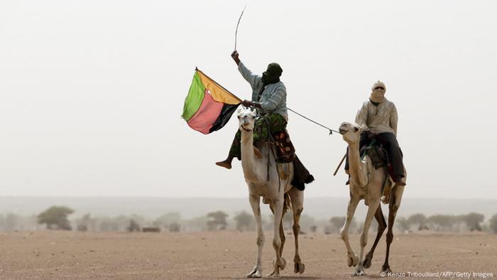 Tuareg auf Kamelen schwenken die Azawad-Fahne Foto: KENZO TRIBOUILLARD/AFP/Getty Images