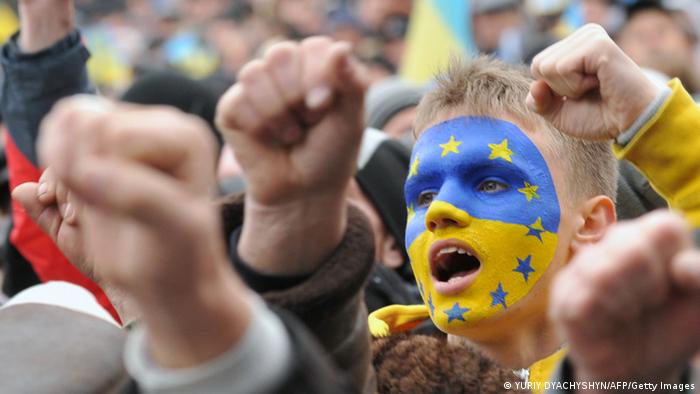 Proteste in Kiew. Ein Mann mit blau-gelb bemaltem Gesicht