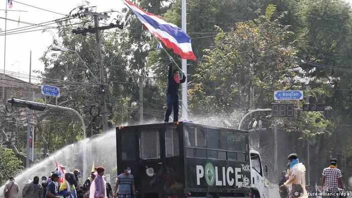 epa03973716 Thai anti-government protesters commander a police truck and taunt police at Government House as street battles for control of the seat of government continue in Bangkok, Thailand, 02 December 2013. Thousands of protesters vowed to take control of government ministries and offices including the seat of Government House in an effort to oust the government of Prime Minister Yingluck Shinawatra and its defacto leader from afar her brother Thaksin Shinawatra. EPA/BARBARA WALTON