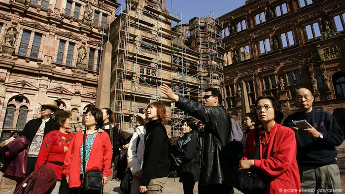 Eine Gruppe Touristen aus Japan steht bei strahlendem Sonnenschein im Hof des Heidelberger Schlosses. (Foto: picture-alliance/ dpa/dpaweb)