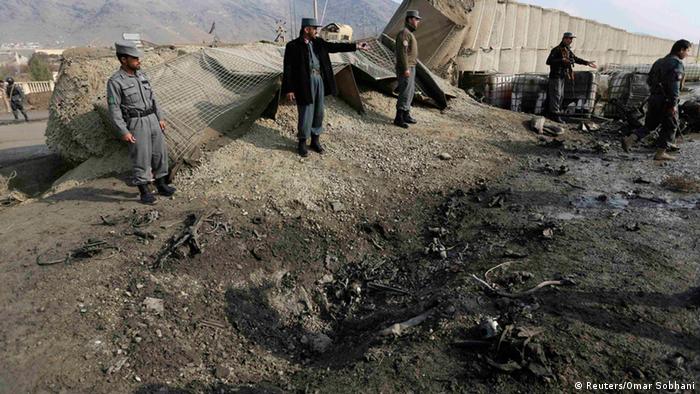 Afghanische Polizisten stehen nach Selbstmordanschlag auf einen Bundeswehrkonvoi während Besuch des Verteidigungsministers am 11. Dezember 2013 am Tatort in Kabul. (Foto: REUTERS/Omar Sobhani)