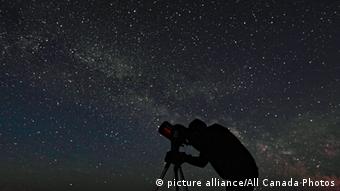 Ein Mann fotografiert den nächtlichen Sternenhimmel
