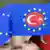 The crescent and star of the Turkish flag inside the EU flag's circle of stars