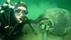 A diver inspects a bomb submerged underwater A diver inspects a bomb submerged underwater