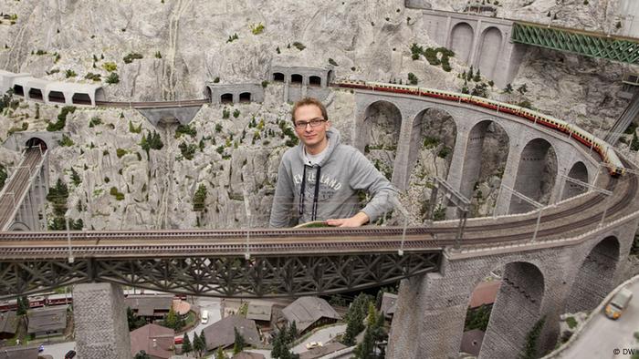 Sebastian, Bandmitglied von EINSHOCH6, sitzt in der Modelleisenbahn-Landschaft in Hamburg. (DW)
