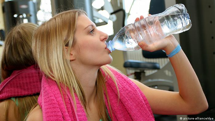 Deutschland Fitness Frau im Fitness-Studio trinkt Wasser