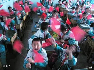 School children wave their Chinese national flag in their classroom as they watch the launch of the country's second manned spacecraft Shenzhou VI in Jiuquan city, China's northwestern Gansu Province, on Oct 12, 2005.The rocket carrying two Chinese astronauts blasted off Wednesday from a base in China's desert northwest, returning the country's manned space program to orbit two years after its history-making first flight. (AP Photo/EyePress)