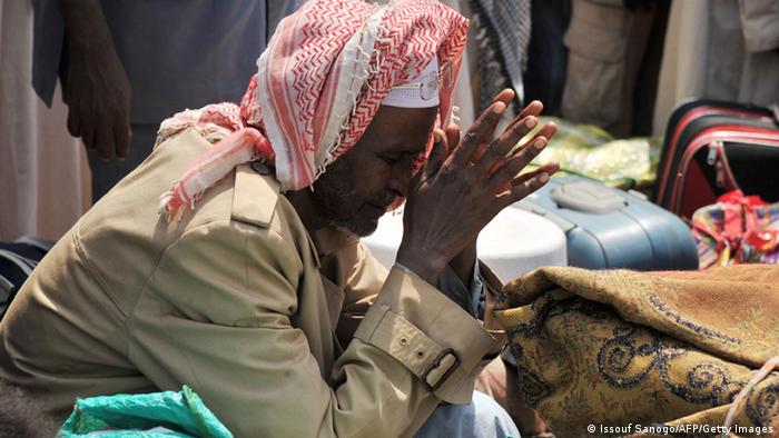 A man closes his eyes and folds his hands in contemplation. Photo: AFP PHOTO/ ISSOUF SANOGO (Photo credit should read ISSOUF SANOGO/AFP/Getty Images)