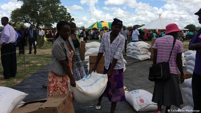 Residents of Siphambi take delivery of sacks of food from the WFP