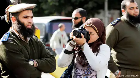 A journalist take pictures of Egyptian Salafi Muslims, unseen, during a protest in support of bearded police officers who were prevented from carrying out their work in the interior ministry, in front of the Shura Council, the upper house of Parliament, in Cairo, Egypt. (AP Photo/Amr Nabil, File)