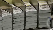 Just cut stacks of $100 bills make their way down the line at the Bureau of Engraving and Printing Western Currency Facility in Fort Worth, Texas, Tuesday, Sept. 24, 2013. (AP Photo/LM Otero)