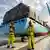 Workers standing in front of a container ship belonging to Maersk Line