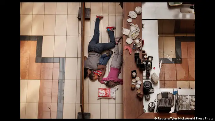Zwei Menschen kauern auf dem Boden - (Foto: World Press Photo 2014 Tyler Hicks / Reuters)