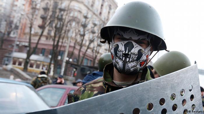 Участник протестов на Майдане в маске и в каске 