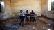 Three schoolboys sit at a desk in a damaged classroom in East Darfur, Sudan. Three schoolboys sit at a desk in a damaged classroom in East Darfur, Sudan.