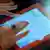 Frauenhände halten ein Tablet-Computer mit persicher Schrift