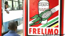 An unidentified man waits for transport at a bus stop with a campaign poster of the ruling Frelimo party next to him a day before elections in Maputo, Mozambique, Tuesday, Nov. 30, 2004. Mozambique is holding parliamentary and presidential elections Dec. 1 and 2. (AP Photo/STR)