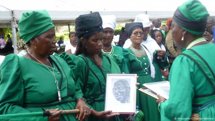 Herero women hold up a picture and remember the victims of the genocide