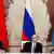 Presidents of Russia, Belarus and Kazakhstan seated in front of national flags.
