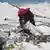 A climber picks up trash on Mount Everest