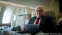 Außenminister Frank-Walter Steinmeier schaut am 25.03.2014 auf dem Flug des Airbus A340-300 Konrad Adenauer von Addis Abeba in Äthiopien nach Daresalam in Tansania in seine Unterlagen. Außenminister Steinmeier musste seinen Aufenthalt in Addis unfreiwillig verlängern, da die Maschine der Flugbereitschaft nach Rauchentwicklung zunächst nicht nach Tansania weiterfliegen konnte. Foto: Michael Kappeler/dpa