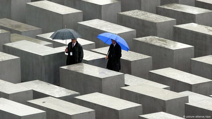 Les gens marchent entre les piliers en béton lors de l'inauguration du site commémoratif de l'Holocauste à Berlin le 10 mai 2005