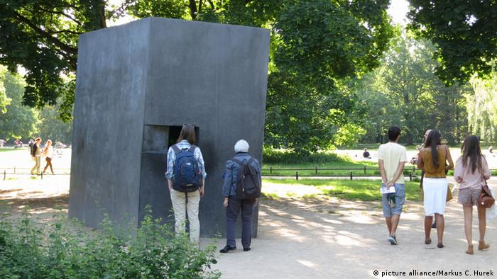 People look in a window of the memorial in the Tierpark garden in Berlin. 