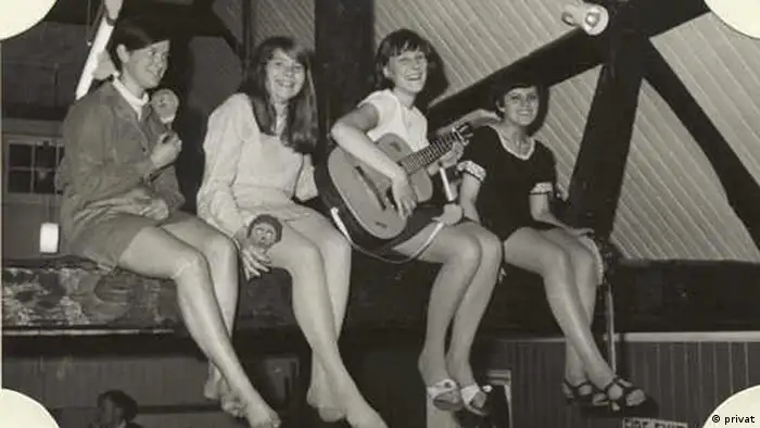 Die vier jungen Mädchen der Folk-Band auf einem Balken sitzend.