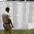 Полицейский в Индии изучает списки голосования