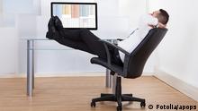 Side view of relaxed young businessman sitting feet up at office desk. apops - Fotolia