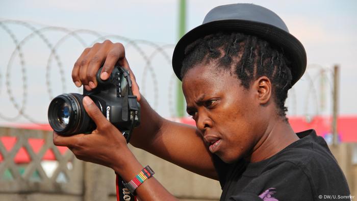 Picture of Zanele Muholi behind a camera lens from 2014