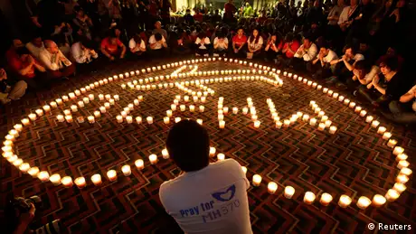 Candles spell out MH 370 in a heart shaped border 