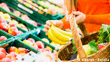Woman in supermarket at the fruit shelf shopping for groceries, she is putting a banana in her basket. #62585645 Copyright: Kzenon - Fotolia