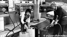 Eine Frau und ein Junge füllen am 7.11.1973 an einer Tankstelle Benzinkanister mit Treibstoff. Benzinkanister mit 20 und 10 Litern Fassungsvermögen sind kaum noch zu haben. Der Bundesverband des Deutschen Tankstellen- und Garagengewerbes hat am 7.11.1973 die Autofahrer aufgerufen, auf Hamsterkäufe von Benzin und Dieselkraftstoff zu verzichten.