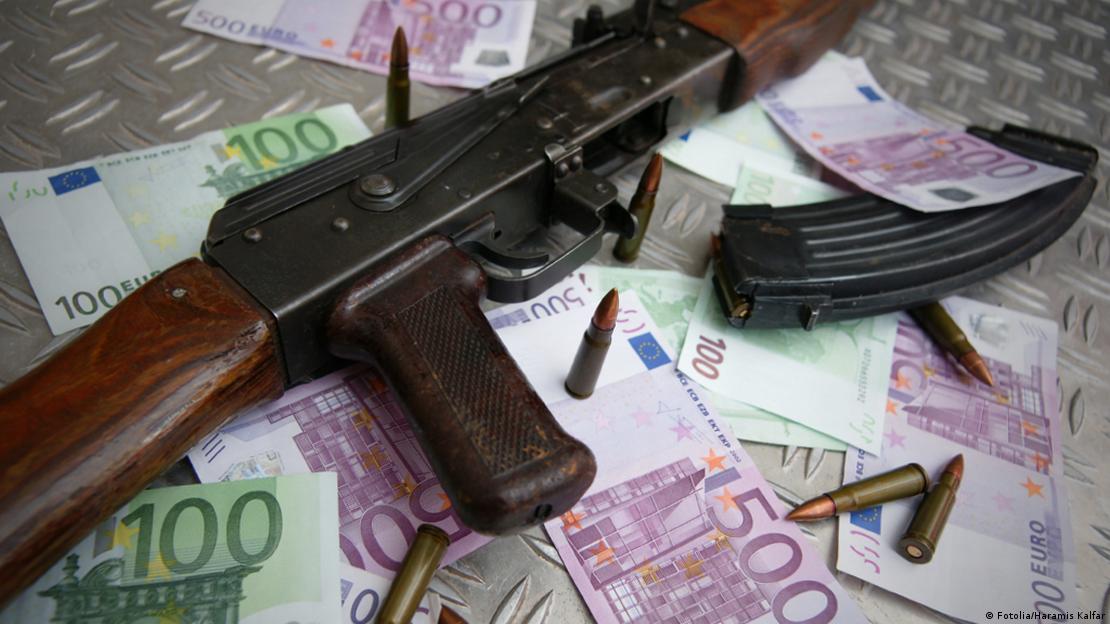 Euro banknotlarının üstünde bir kalaşnikof (silah) ve mermiler