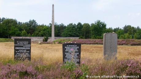 A memorial of gravestones with the names of victims in a field next to Bergen-Belsen