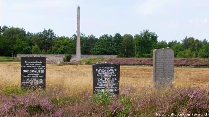 A memorial of gravestones with the names of victims in a field next to Bergen-Belsen