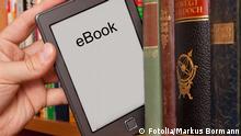 #41302161 - eBook vs Buch, e-Reader aus einem Bücherregal ziehen © Markus Bormann
